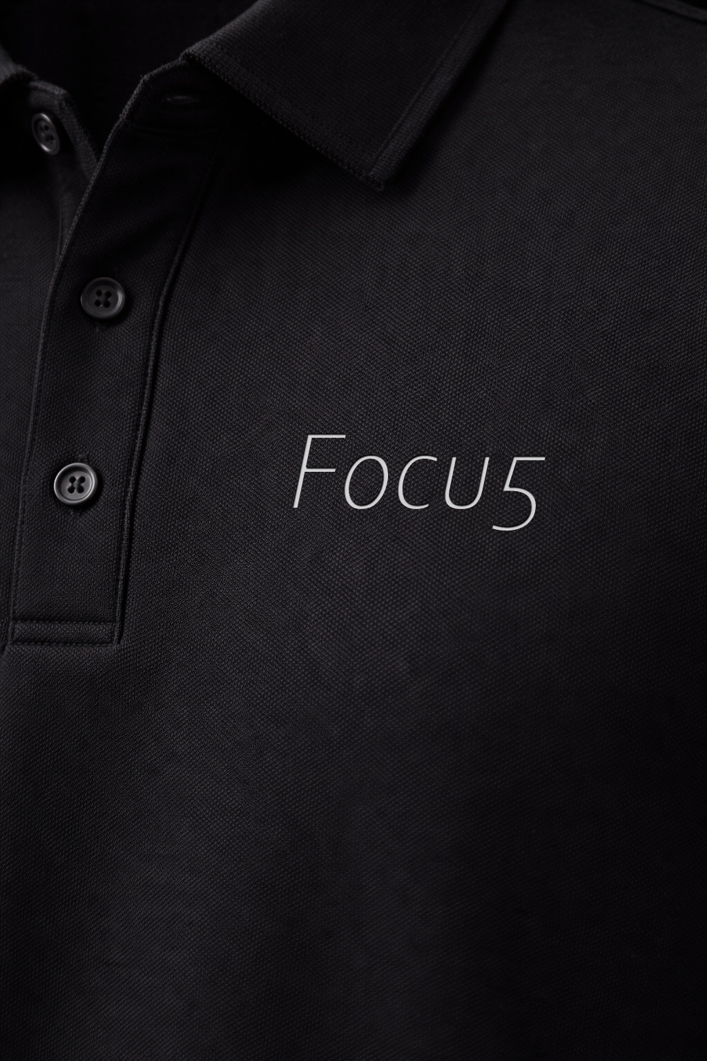 Black polo shirt embroidered FOCU5 logo close-up